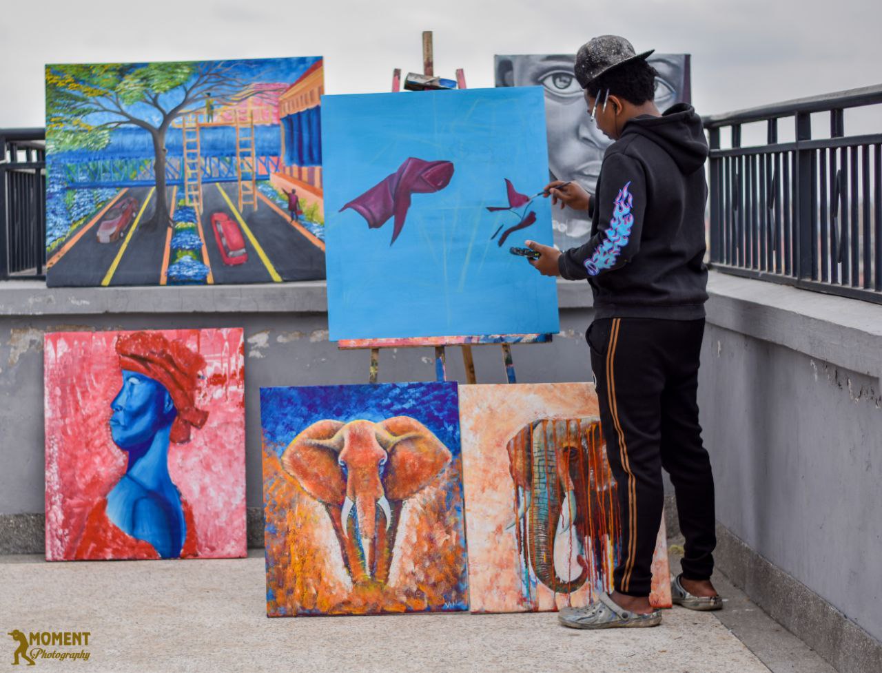 Artist with a selection of framed original paintings