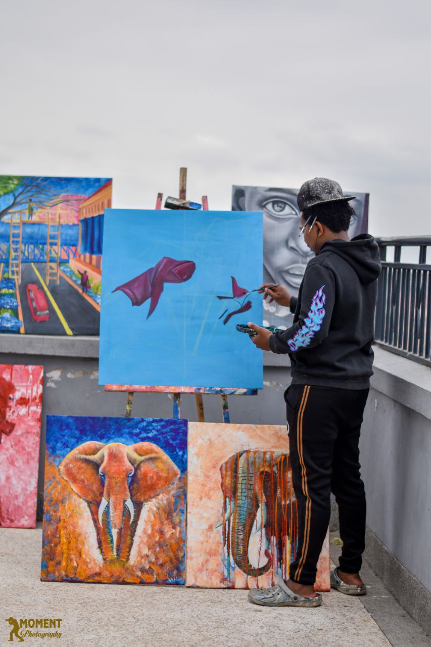 Artist working among several original paintings