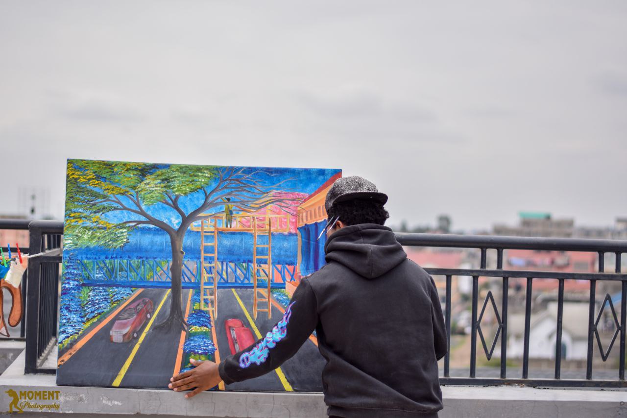 Artist positioning a colorful cityscape painting